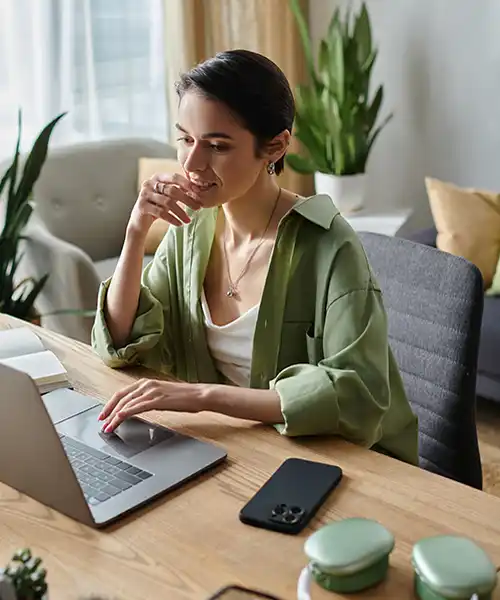 Mujer joven está sentada en un espacio de estudio en casa, con buena iluminación y ergonomía para estudiar desde casa.