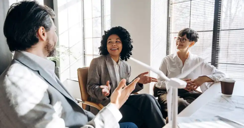 Fotografía de egresado del diplomado en emprendimiento en sesión estratégica analizando métricas y diseñando estrategias de crecimiento en una sala de trabajo colaborativa.