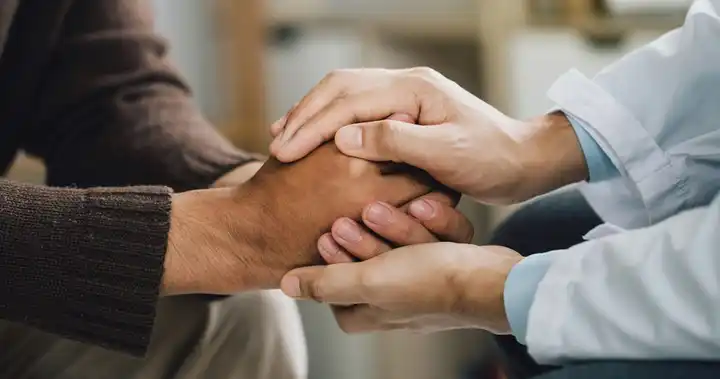 Persona aplicando técnicas de apoyo físico aprendidas en un diplomado en salud mental, para controlar la crisis nerviosa de un paciente.