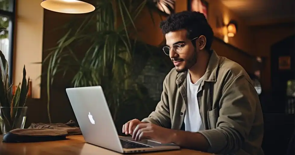 Imagen de un joven pensativo frente a una computadora en su cuarto, reflexionando si estudiar virtual un diplomado.